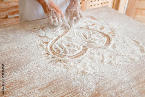 A woman's hand draws a heart on flour, a romantic mood, cooking at home with love
