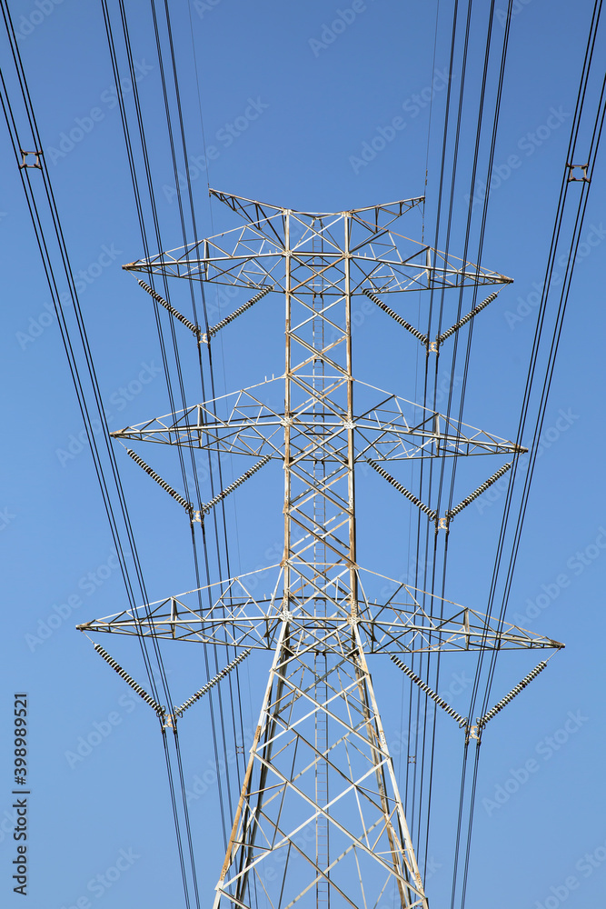High-voltage transmission tower and electricity voltage wiring cable with sky background.