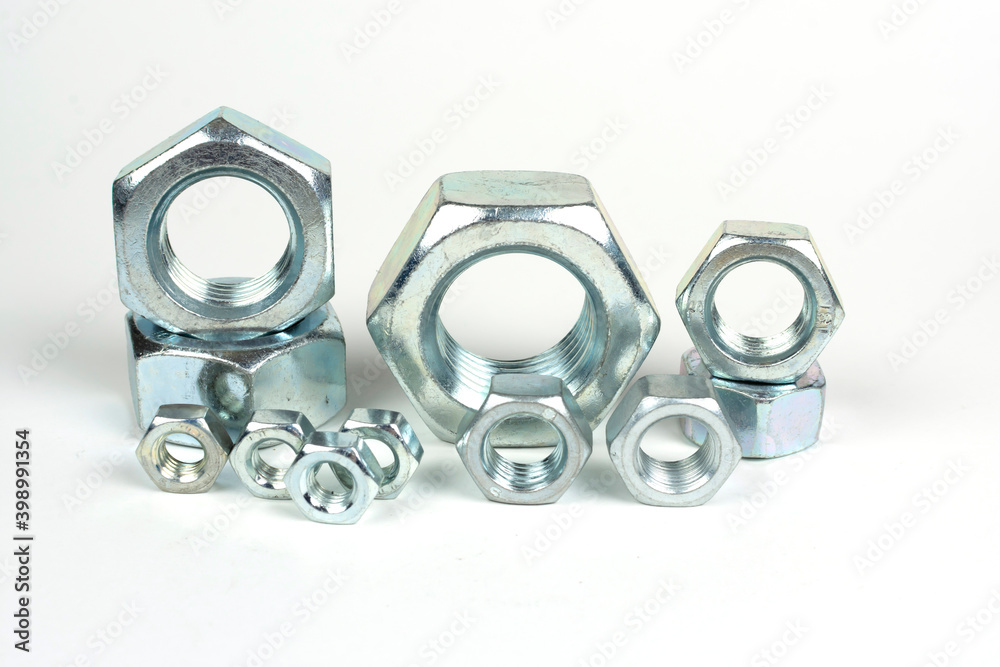 several metal nuts on a white background several metal nuts on a white background