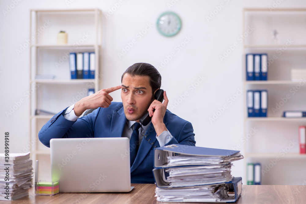 Young male employee unhappy with excessive work Young male employee unhappy with excessive work
