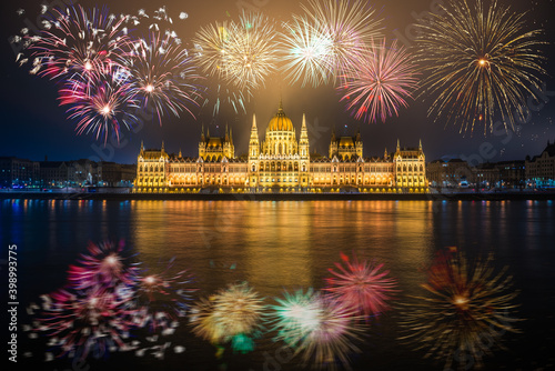 Hungarian parliament with fireworks reflected in Danube river. Budapest