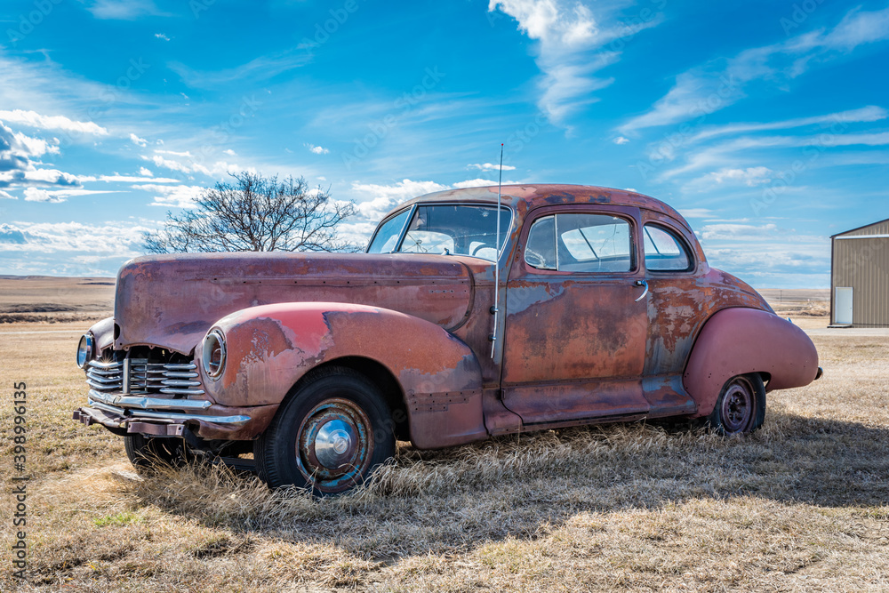 Abandoned vintage red car on the prairies in Saskatchewan