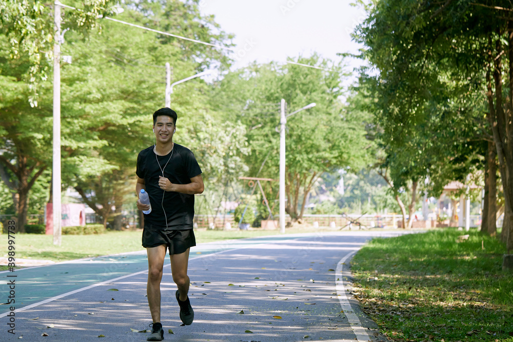A man jogging holding a water bottle