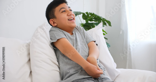 Disabled boy sitting on sofa at home.