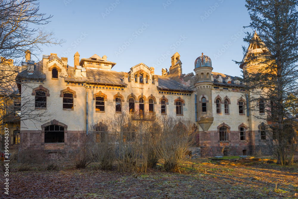 Fototapeta premium View of the abandoned main house of the old Eliseev estate (1912) in the village of Belogorka in early. Leningrad region, Russia