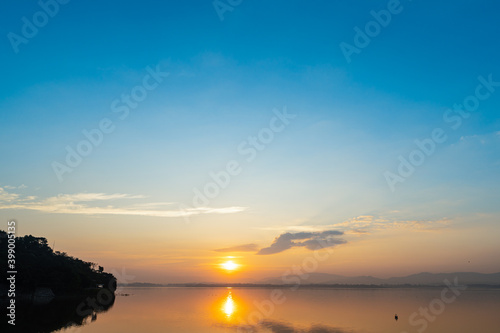 Sunrise at reservoir with mountain blackground and blue sky in morning time. Nature park and outdoor background