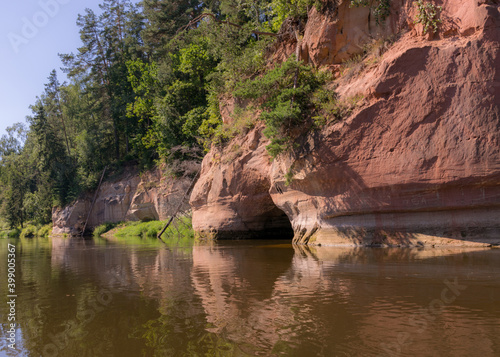 beautiful day on the river, sandstone cliffs and tree reflections in the water, blue sky reflected in the river water