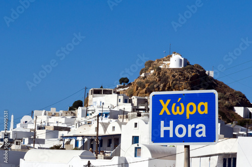 Anafi Chora sign, in the back panorama view on white cycladic village. Cyclades islands, Greece
