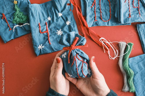 Fabric bags for Christmas gifts and handmade numbers with decorations on the table. Hand made Advent calendar for Christmas