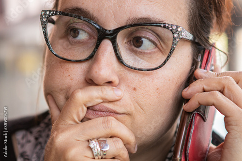 Expressions - Woman talking to the phon, seated in a cefeteria - Super Close UP photo