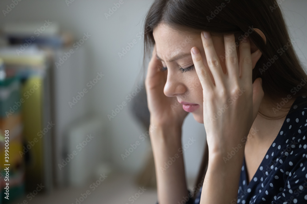 Close up unhealthy young woman suffering from strong headache or chronic migraine, touching temples with closed eyes, unhappy tired businesswoman or student feeling unwell, feeling pain Close up unhealthy young woman suffering from strong headache or chronic migraine, touching temples with closed eyes, unhappy tired businesswoman or student feeling unwell, feeling pain