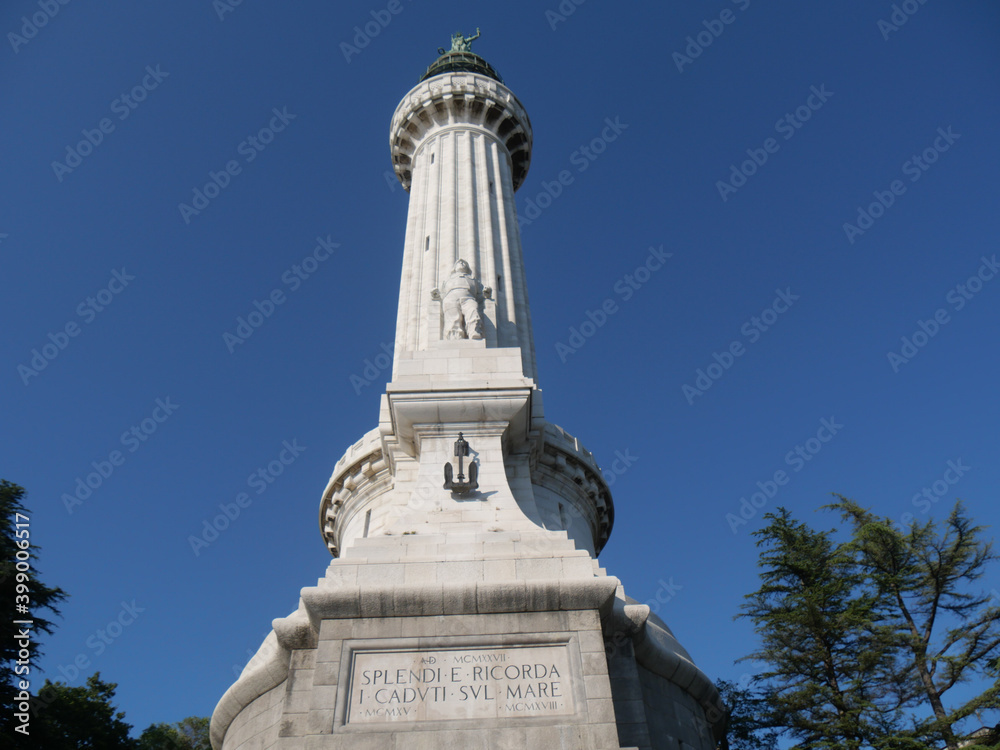 Vittoria Lighthouse in Trieste, exterior covered with blocks of white Istrian stone and surmounted by a copper dome with the lantern and the statue of the Winged Victory. Translation: shine and rememb