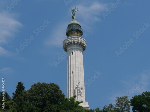 Vittoria Lighthouse in Trieste, exterior covered with blocks of white Istrian stone and surmounted by a copper dome with the lantern and the statue of the Winged Victory. Translation: shine and rememb