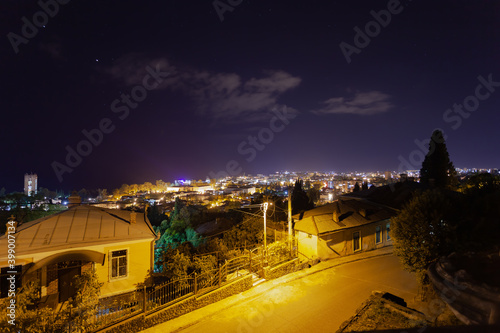 Night city view from above, bottom frame an empty road