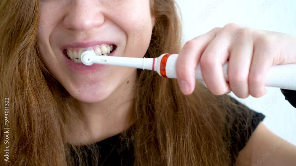 Brush your teeth with an electric toothbrush close-up on a white background. 4K video. Brush your teeth with an electric toothbrush close-up on a white background. 4K video.