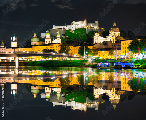 Salzburg at night. City skyline with Festung Hohensalzburg castle and reflection. Austria