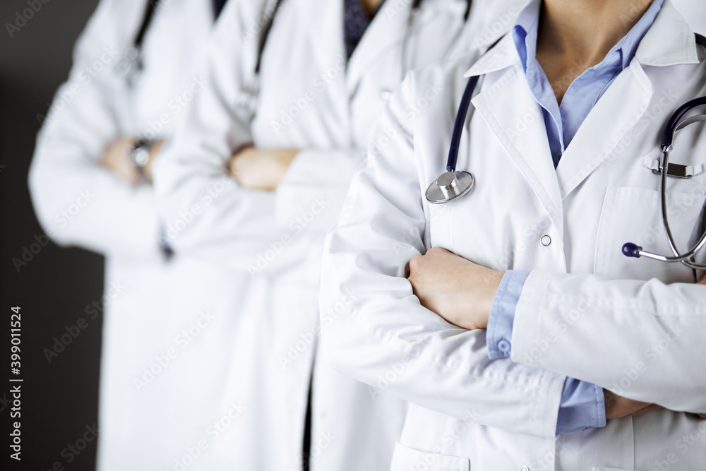 Group of modern doctors standing as a team with arms crossed in hospital office and ready to help patients. Medical help, insurance in health care, best disease treatment and medicine concept Group of modern doctors standing as a team with arms crossed in hospital office and ready to help patients. Medical help, insurance in health care, best disease treatment and medicine concept