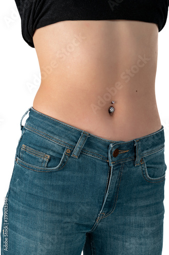 Belly button or navel piercing, of young woman wearing jeans isolated on white. © ErdalIslak