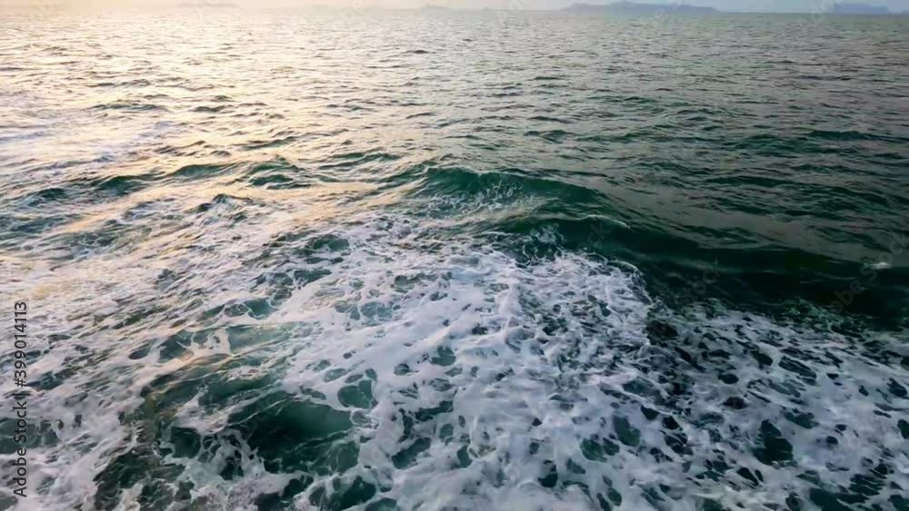 Aerial top view of calm ocean wave with white foam n green sea tide water surface reflaction of pastel goden pink sun light ray on yellow purple sunset sky background with mountain, 4k b-roll footage Aerial top view of calm ocean wave with white foam n green sea tide water surface reflaction of pastel goden pink sun light ray on yellow purple sunset sky background with mountain, 4k b-roll footage