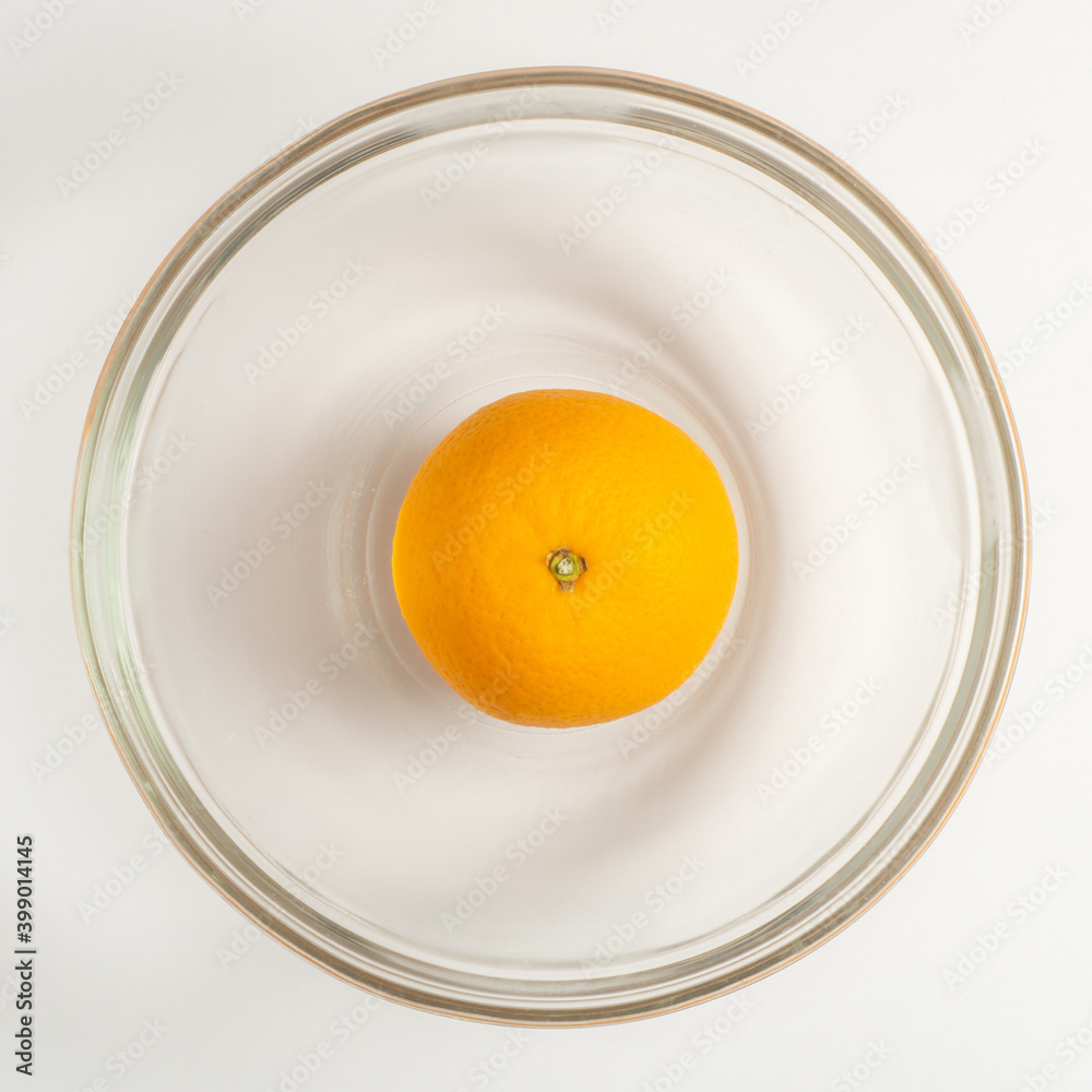 An orange fruit in a bowl. Flat lay view. Square size of photo. An orange fruit in a bowl. Flat lay view. Square size of photo.