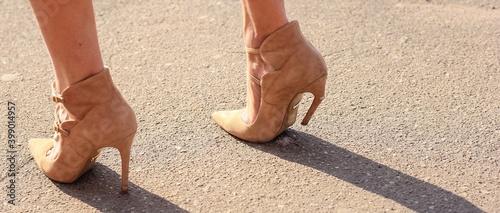 Broken stiletto heel on the shoes wearing by attractive young woman. Banner.