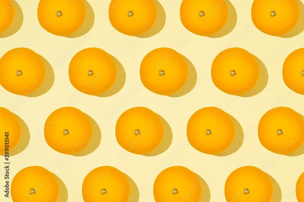 Trendy creative pattern of an orange fruit. Summer creative concept. Flat lay view on a light yellow background. Trendy creative pattern of an orange fruit. Summer creative concept. Flat lay view on a light yellow background.