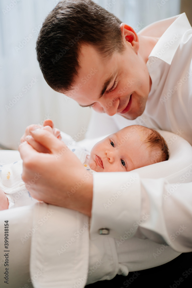 Happy father with young son in a lounger for newborns. father's day Happy father with young son in a lounger for newborns. father's day