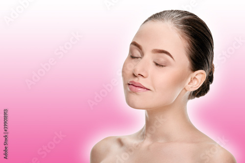relaxed young woman with closed eyes after spa procedures on a pink background with a shaded white outline