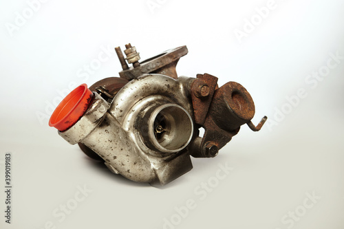 Havily used rusty and carbonized turbocharger on background photo