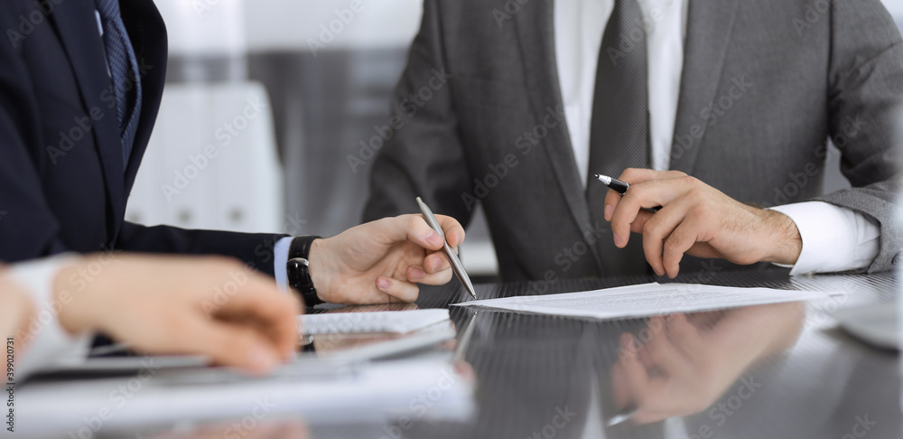 Unknown business people working together at meeting in modern office, close-up. Businessman and woman with colleagues or lawyers discussing contract at negotiation Unknown business people working together at meeting in modern office, close-up. Businessman and woman with colleagues or lawyers discussing contract at negotiation