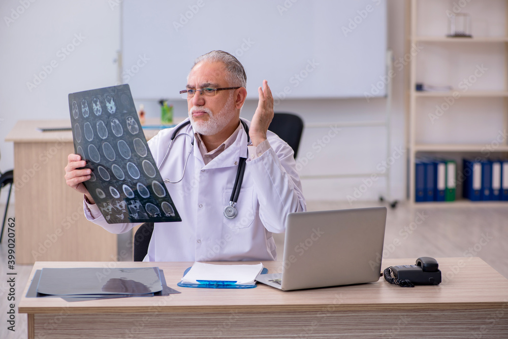 Old male doctor radiologist working in the clinic Old male doctor radiologist working in the clinic