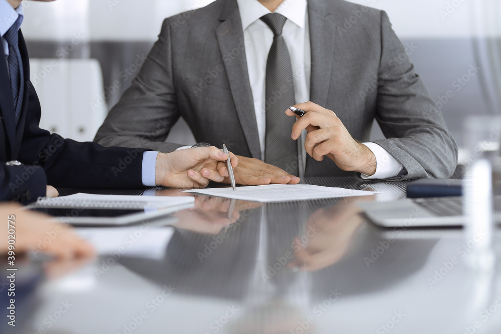 Unknown business people working together at meeting in modern office, close-up. Businessman and woman with colleagues or lawyers discussing contract at negotiation Unknown business people working together at meeting in modern office, close-up. Businessman and woman with colleagues or lawyers discussing contract at negotiation