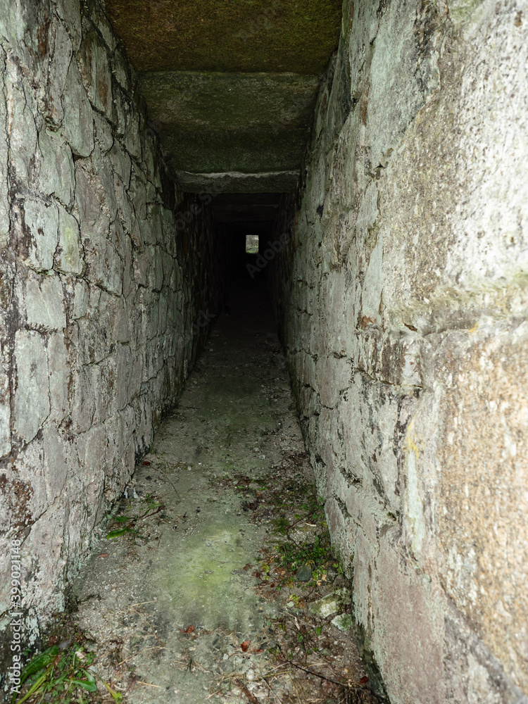 Concrete and stony wall tunnel. Light at the end of the tunnel.