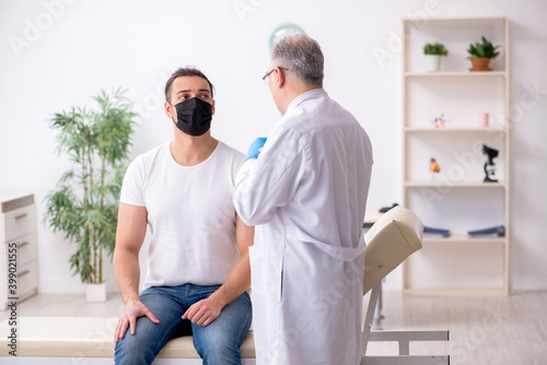 Young man visiting male experienced doctor