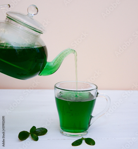 Pouring  chlorophyll tea, drink. Chlorella detox healthy drink in glass on a light background, Healthy drink. Superfood, natural antioxidant