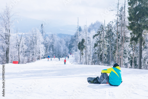man sitting on the top of the hill enjoying view. snowboarding. winter sport activities