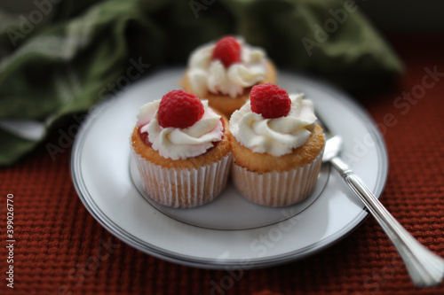 Angle food cupcakes. Homemade cupcakes with raspberry jam and whipped cream frosting topped with a fresh raspberry.