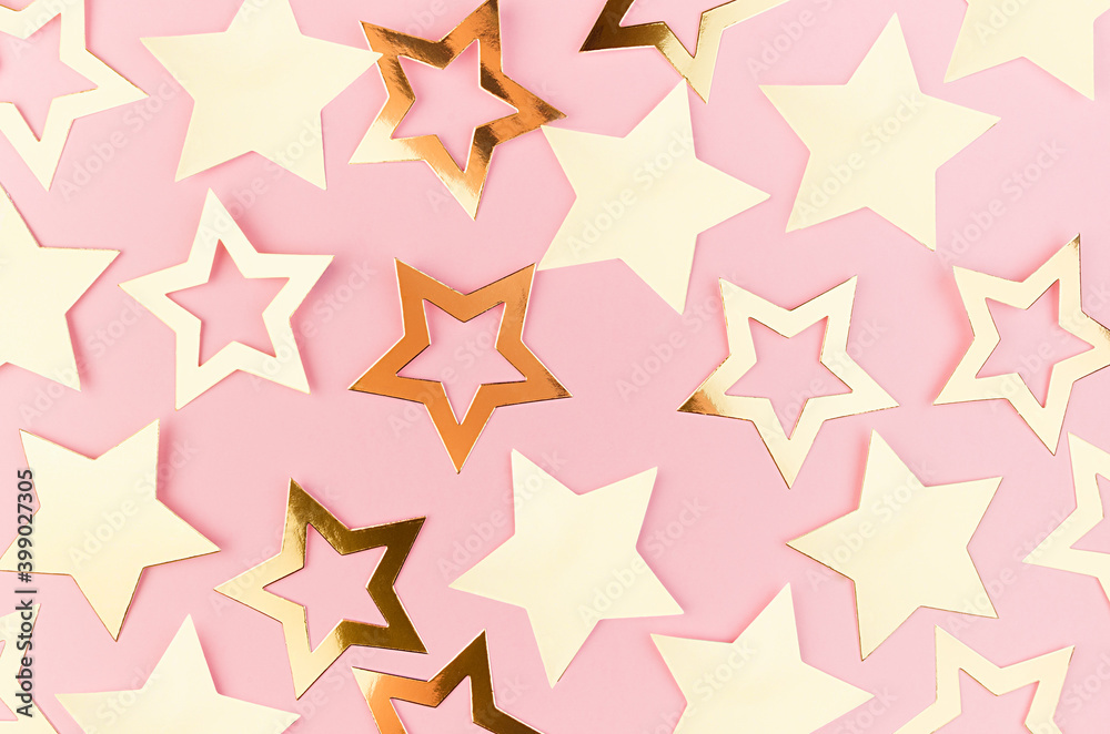 New Year festive abstract background with golden sparkle stars as abstract pattern on pastel pink background.