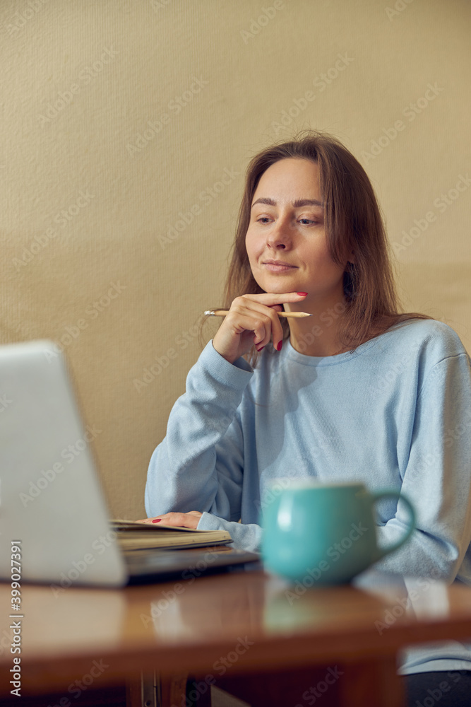 Young cheerful confident and happy freelancer woman is working on laptop at her kitchen at home Young cheerful confident and happy freelancer woman is working on laptop at her kitchen at home