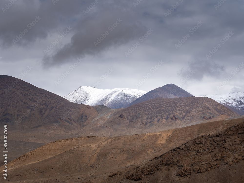Painterly muted colors of high-altitude mountains on the Pamir Highway near Ak Baital pass in Murghab district, Gorno-Badakshan, Tajikistan on a gloomy overcast day