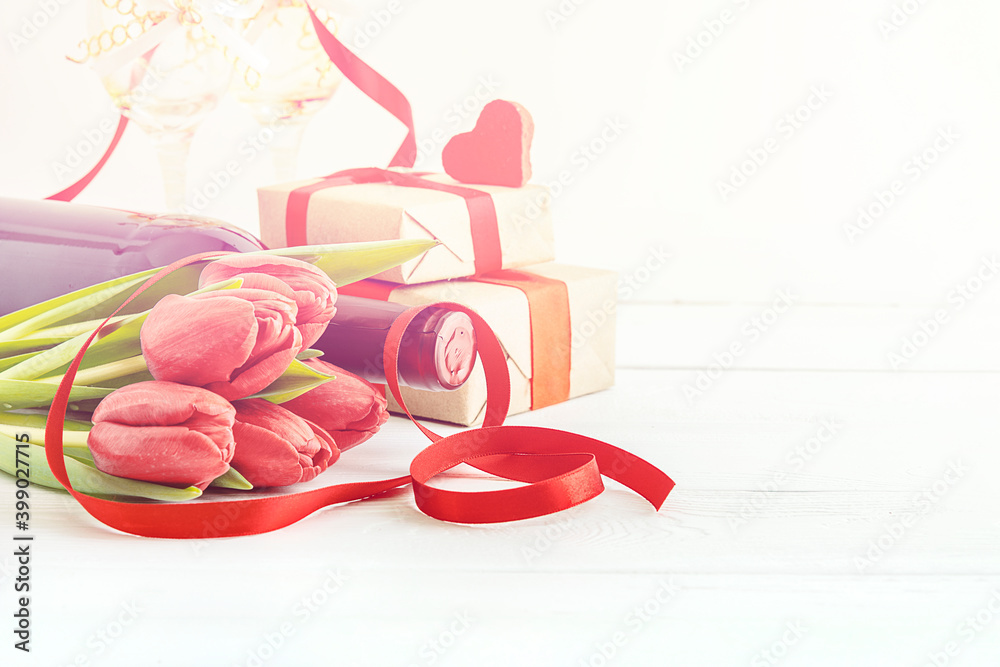 The concept of a women's holiday. Red tulips with gifts on a white background with copies of the space.