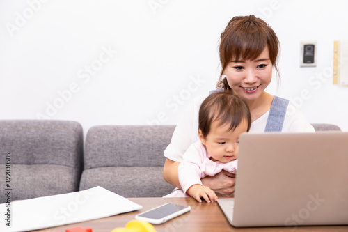 パソコンを使う主婦と赤ちゃん
