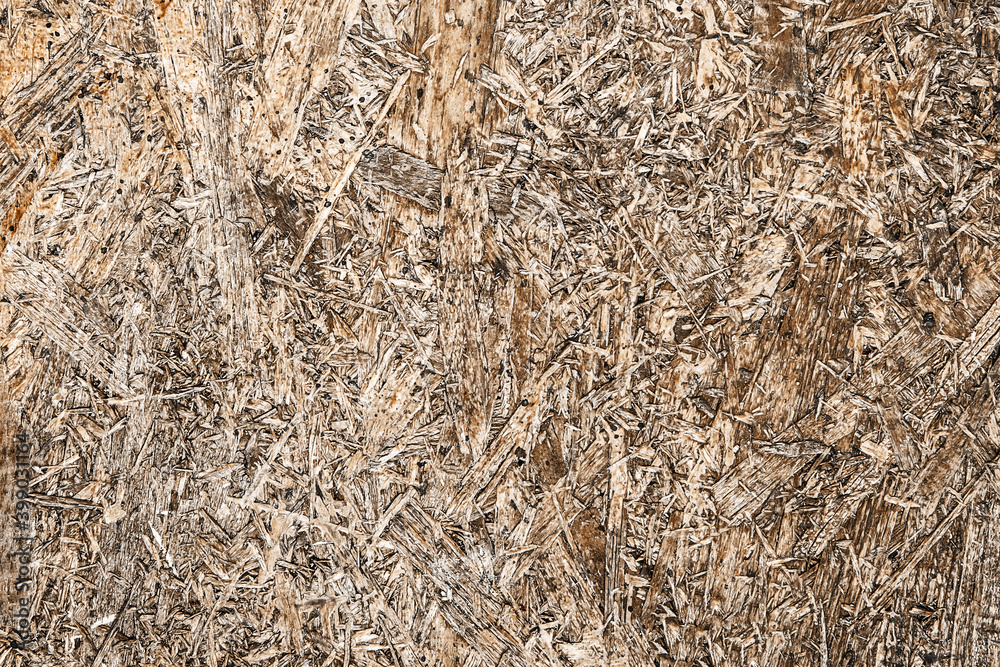 OSB board texture. Brown wooden background. Simple pressed chipboard pattern. Chip board background. Grunge construction site texture. OSB board texture. Brown wooden background. Simple pressed chipboard pattern. Chip board background. Grunge construction site texture.