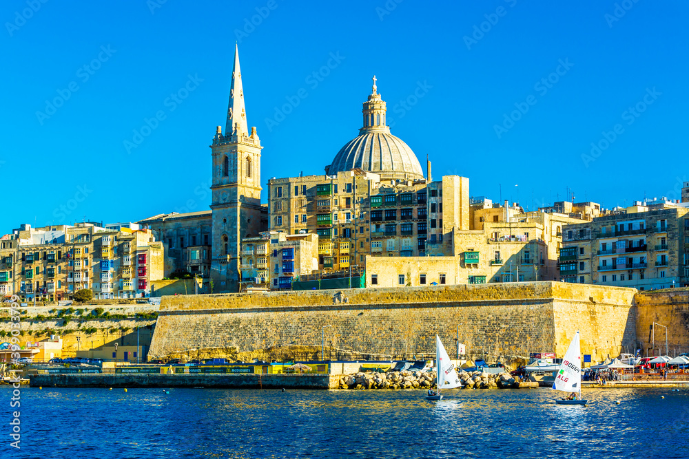 Valletta skyline with the St. Pauls Cathedral and sailboats in the Marsamxett Harbour in Valletta, Malta.