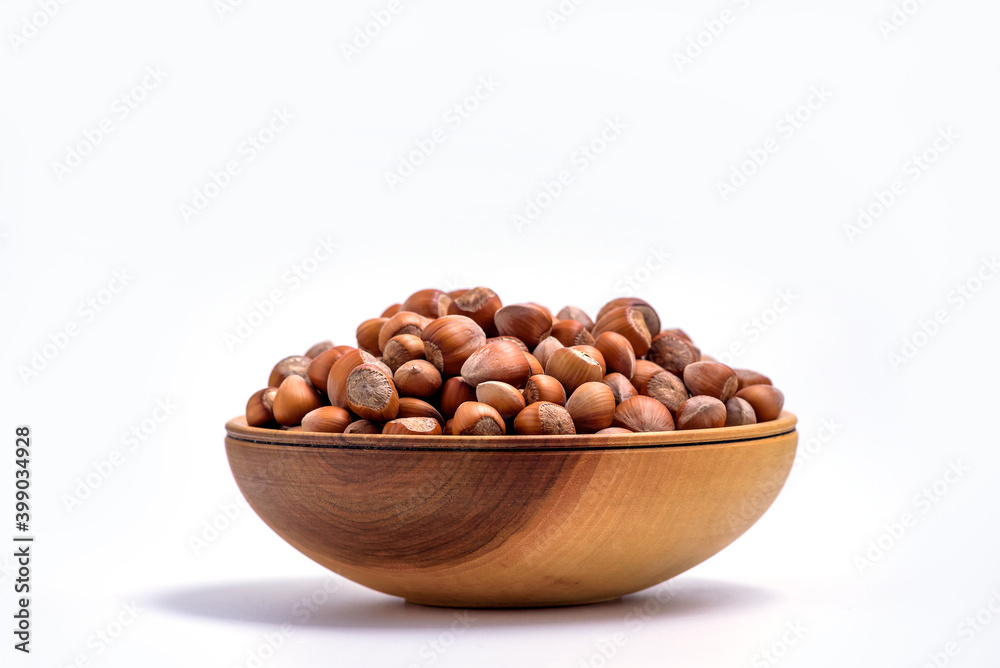 Hazelnuts in a wooden bowl on white background. Solid ripe Hazelnuts Hazelnuts in a wooden bowl on white background. Solid ripe Hazelnuts