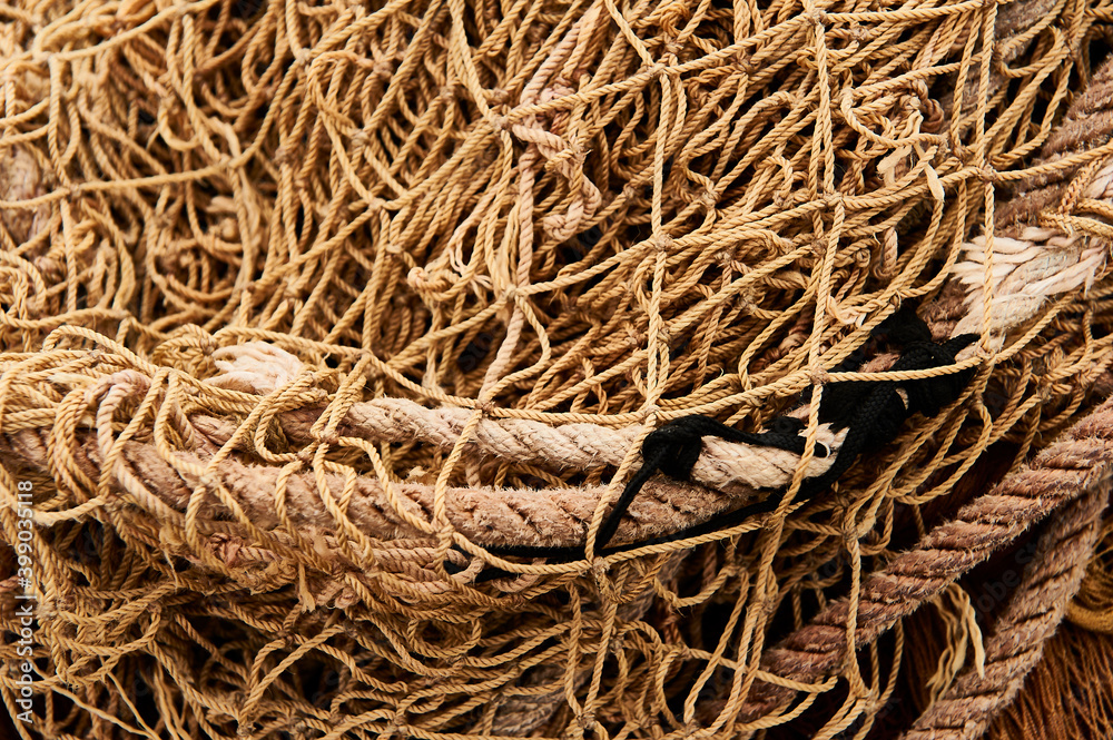 Pile of commercial fishing nets on a fishing quay. Pile of commercial fishing nets on a fishing quay.