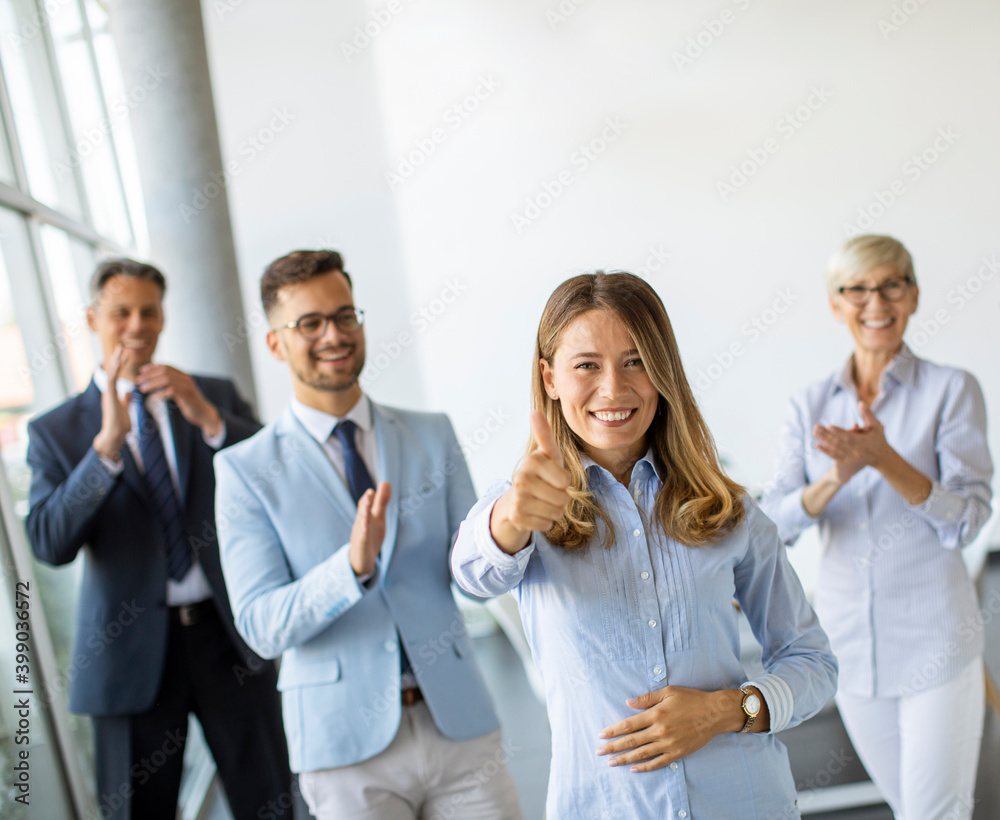 Group of positive businesspeople standing together in the office Group of positive businesspeople standing together in the office