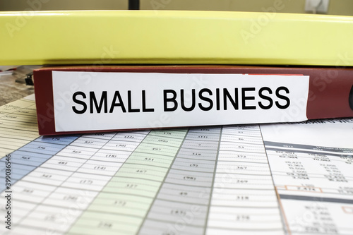 small business is written on a red folder that lies on the documents with numbers. Business concept