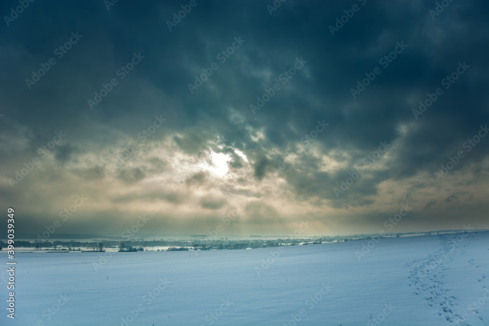 Winter landscape covered with snow and cloudy sky