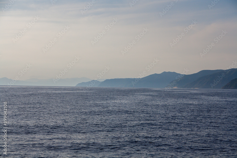 A view from the sea towards mountains with sea fog A view from the sea towards mountains with sea fog